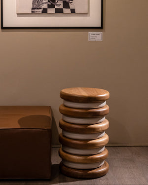 Supellex Home mesa auxiliar cilíndrica Querqus en madera natural de nogal y anillos blancos ubicada en espacio de exhibición junto a mobiliario contemporáneo