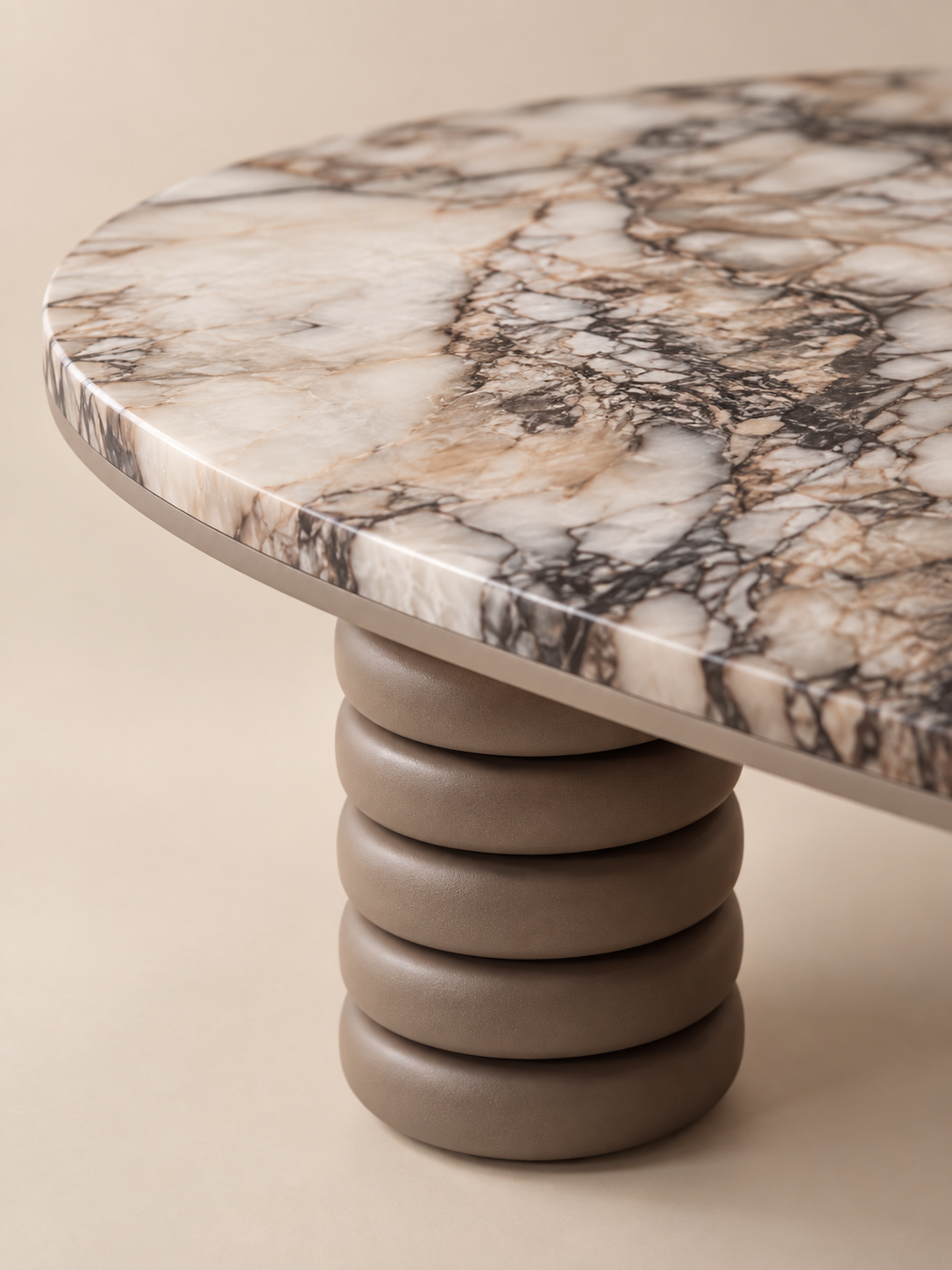Supellex Home mesa de centro ovalada Gaia con superficie en mármol veteado y tres patas cilíndricas de anillos apilados en color topo - vista en perspectiva detalle