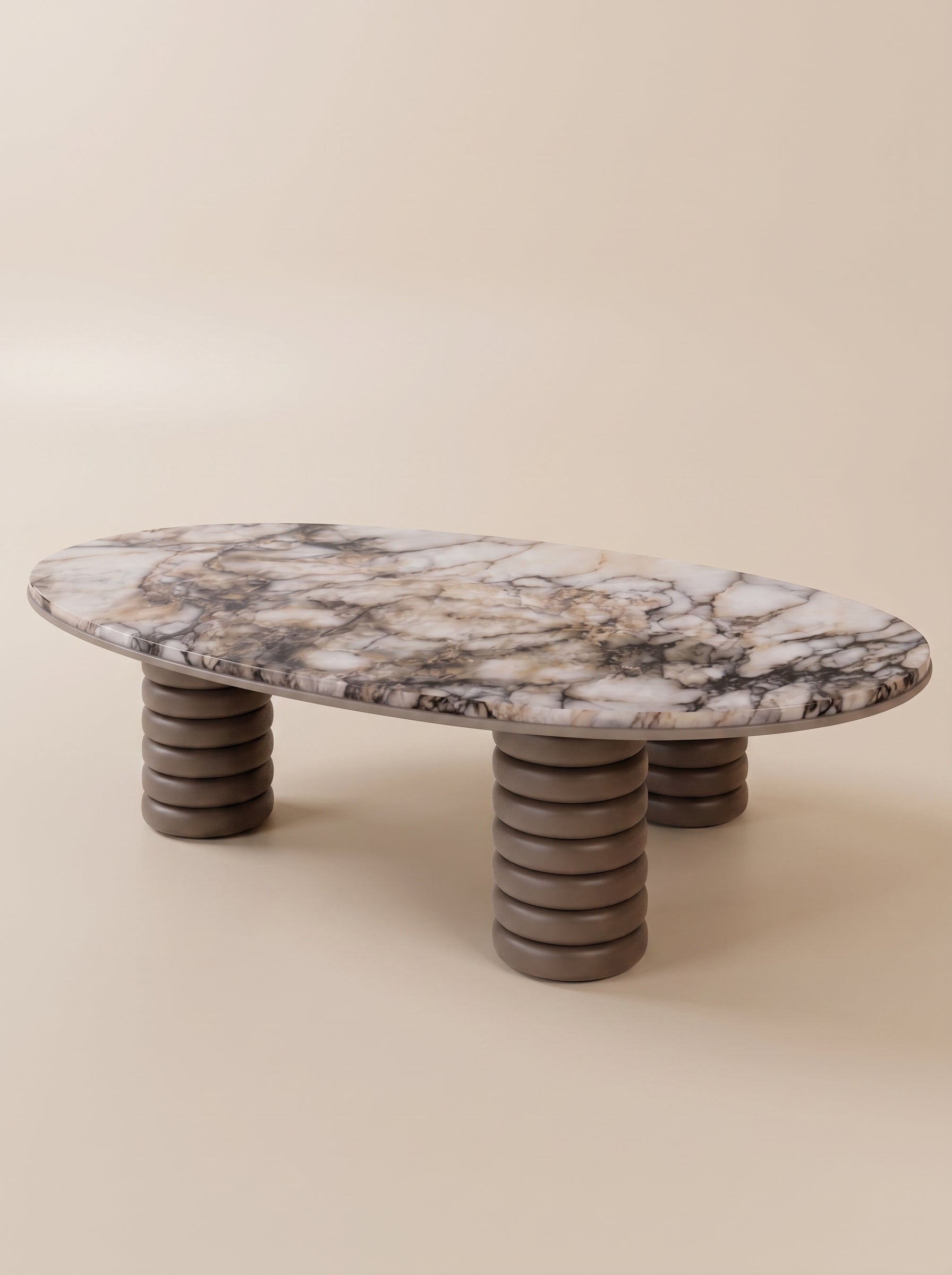 Supellex Home mesa de centro ovalada Gaia con superficie en mármol veteado y tres patas cilíndricas de anillos apilados en color topo - vista en perspectiva
