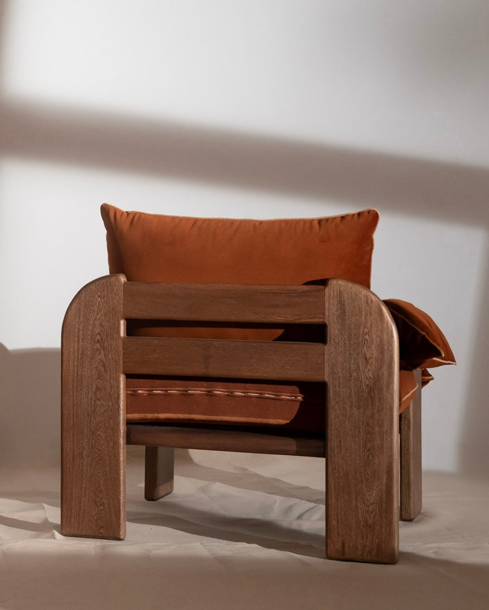 Supellex Home poltrona Monarch tapizada en tela color terracota con estructura en madera - vista posterior