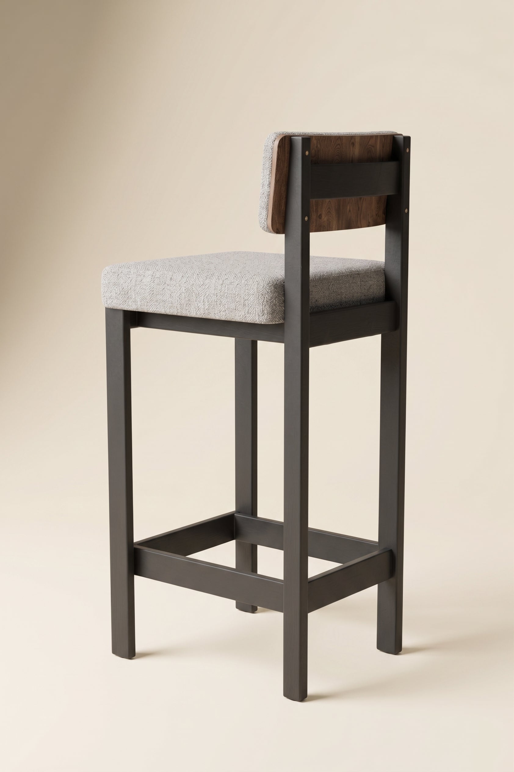 Supellex Home silla de barra Tabella color gris con patas en madera de color negro y detalle en respaldo - vista trasera tres cuartos