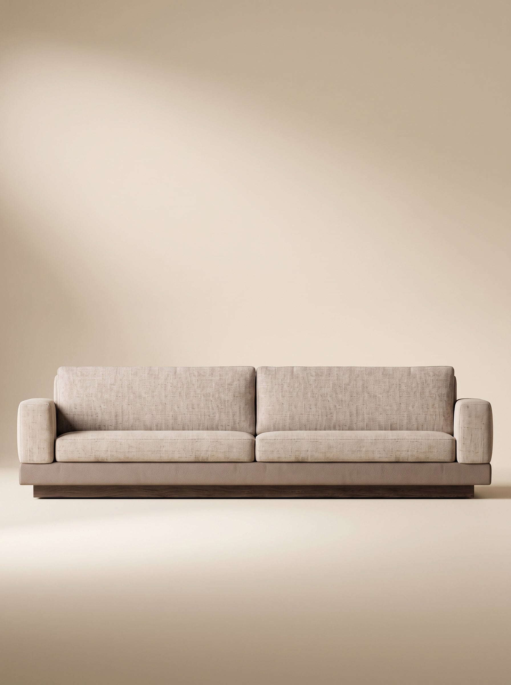 Sofá lineal de tres puestos Bali tapizado en tela texturizada beige con base inferior combinada en tono taupe y zócalo de madera natural.