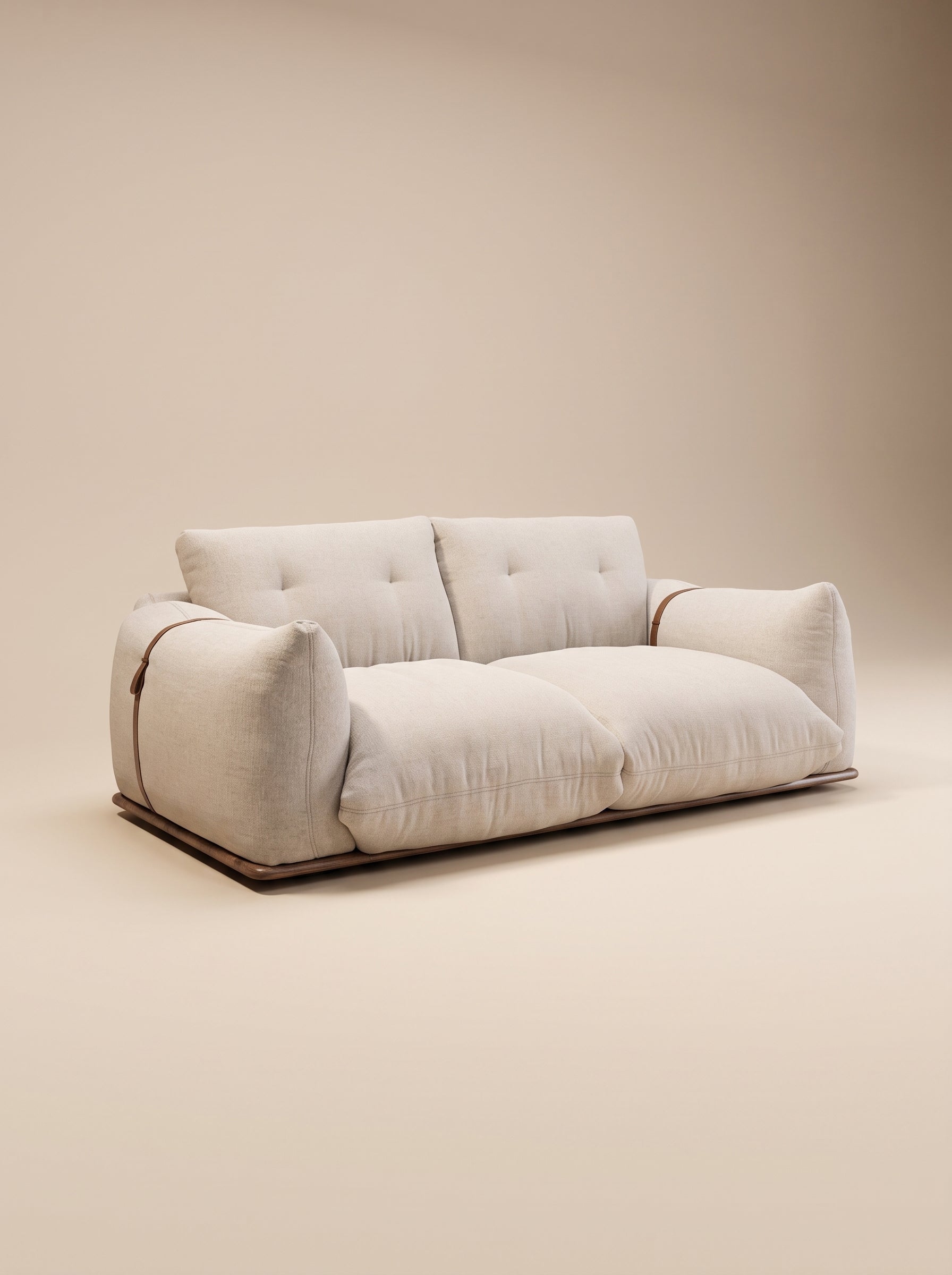 Sofá de dos plazas Cluddo de silueta mullida y perfil bajo tapizado en tela texturizada beige claro con base de madera a ras de suelo.
