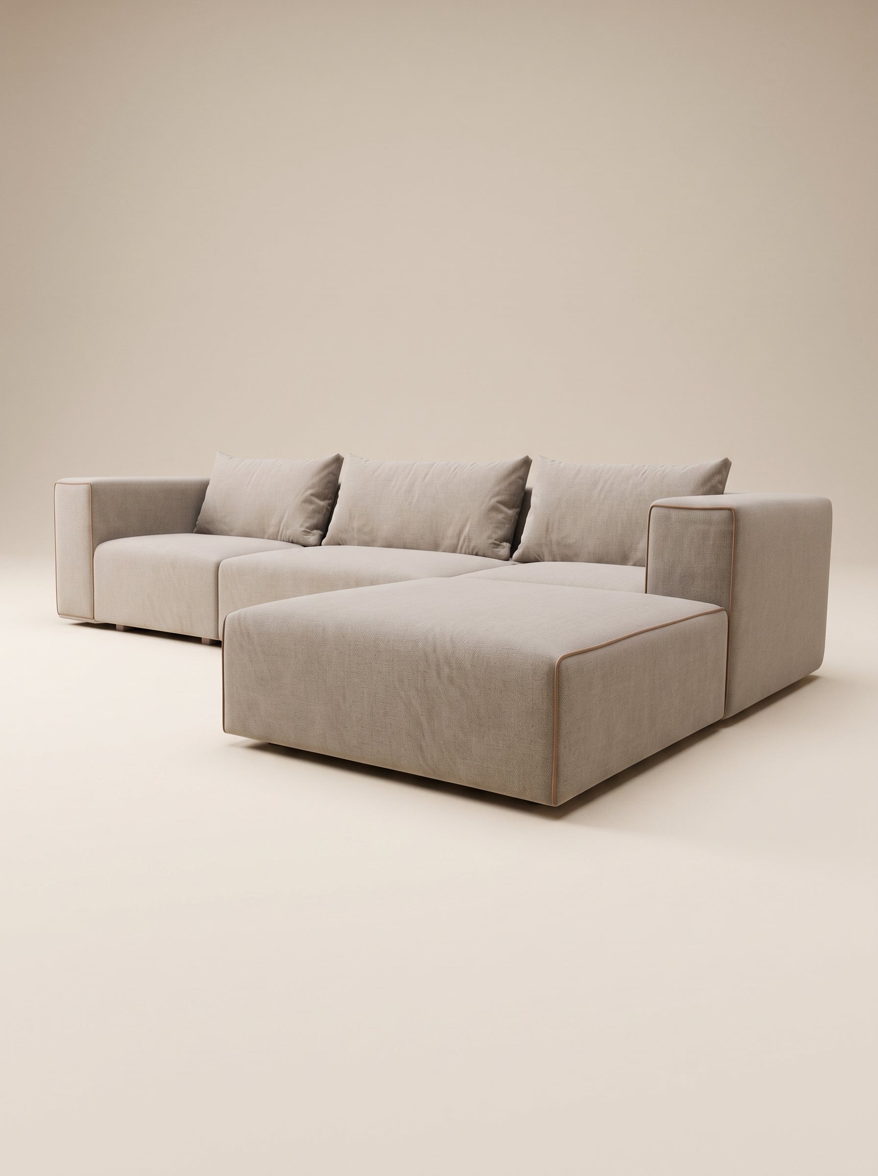 Vista frontal de sofá modular Magnum con configuración de chaise longue a la derecha, tapizado en tejido texturizado tono crema claro, con tres cojines de respaldo sueltos, ribete decorativo en color marrón oscuro en los contornos y patas cortas de madera natural, presentado en un estudio minimalista.