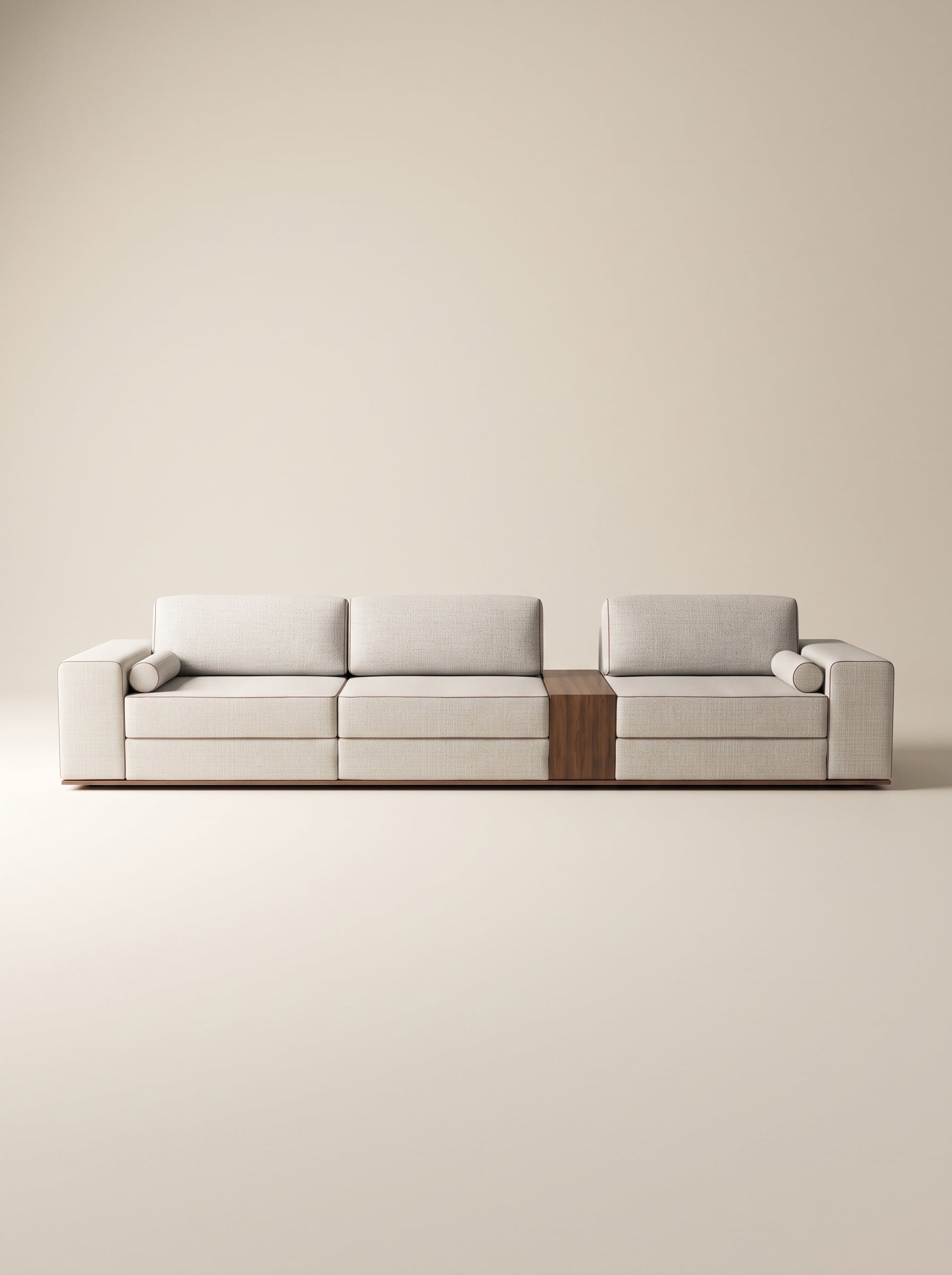 Sofá modular Reggio tapizado en tela neutra texturizada con mesa lateral integrada de madera natural y cojines cilíndricos sobre fondo blanco.